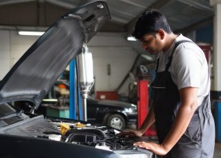 garagiste regarde le moteur d'une voiture qui a le capot ouvert