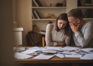 un couple regarde des documents avec tristesse